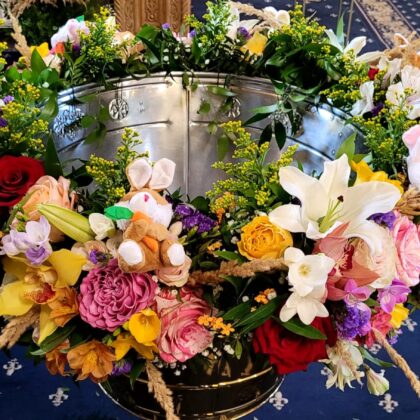 Aranjament cristelniță colorat cu flori naturale și jucării de pluș