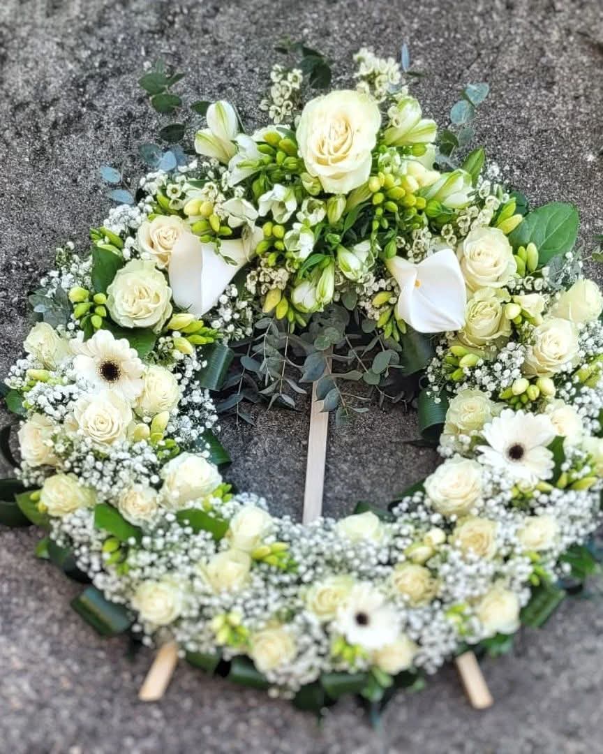 Coroană funerară cu trandafiri albi, frezii, cale, gerbera și gypsophila